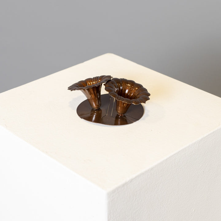 2 arm metal saguaro flowers in a copper powder coat on a white table, with a grey background.