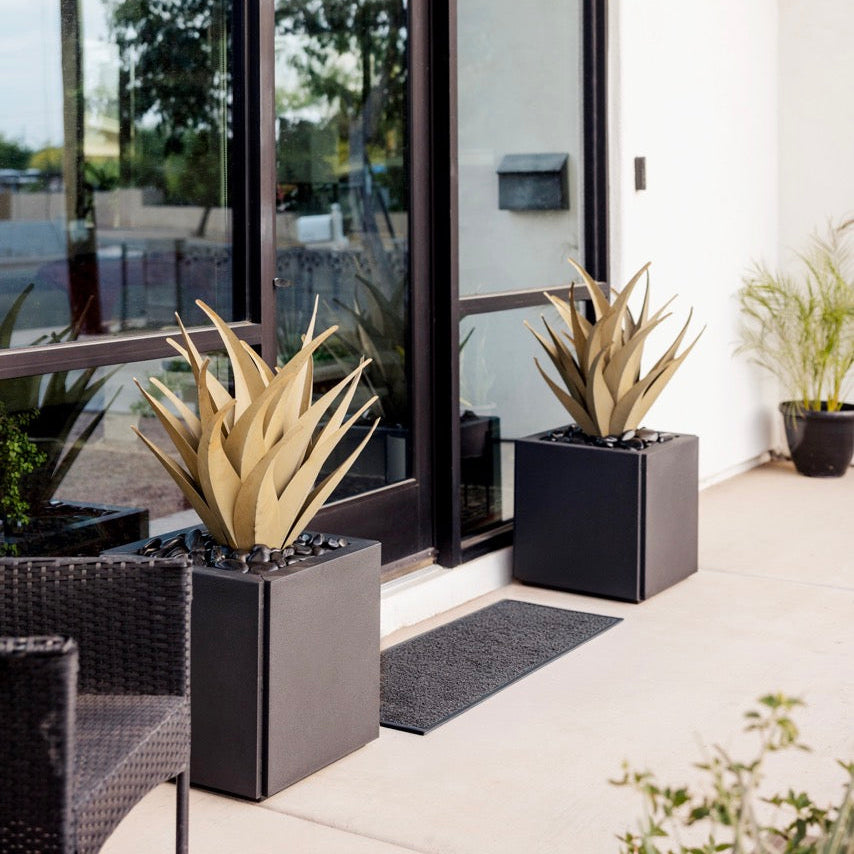 Modern outdoor patio with glass doors, steel agaves in planters.