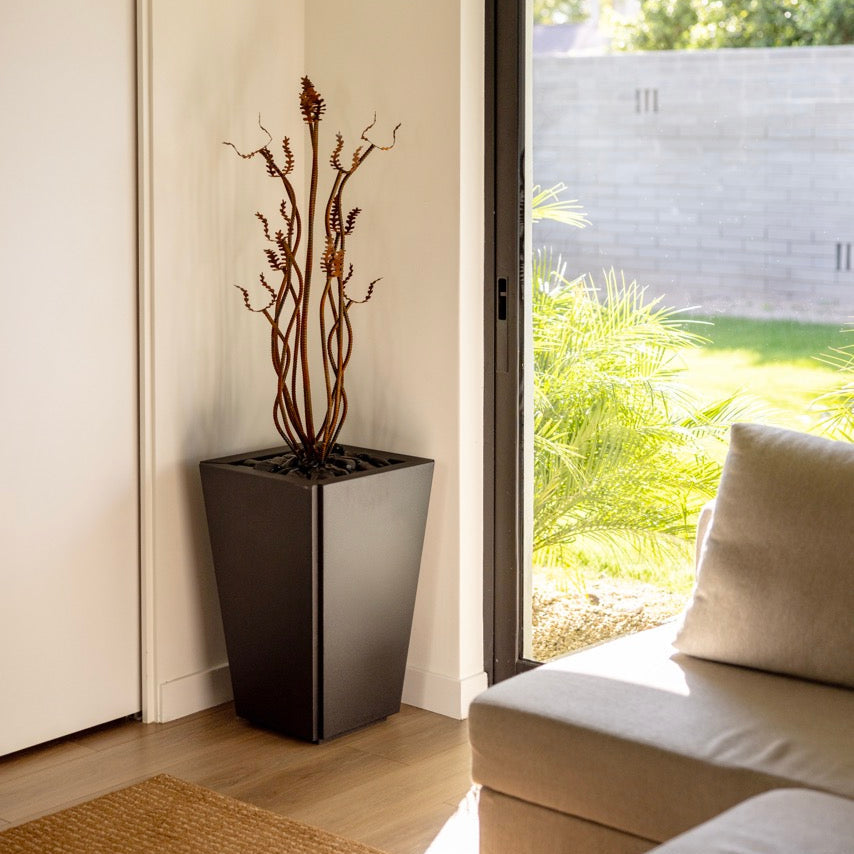 Modern interior with a steel plant in a pot near a sliding glass door.