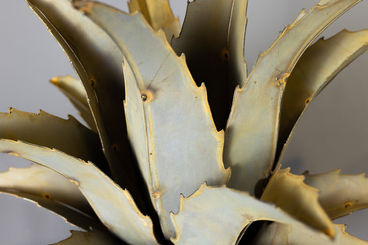 A handcrafted metal Americana Agave sculpture, close up shot on a grey background, with a lifelike design.