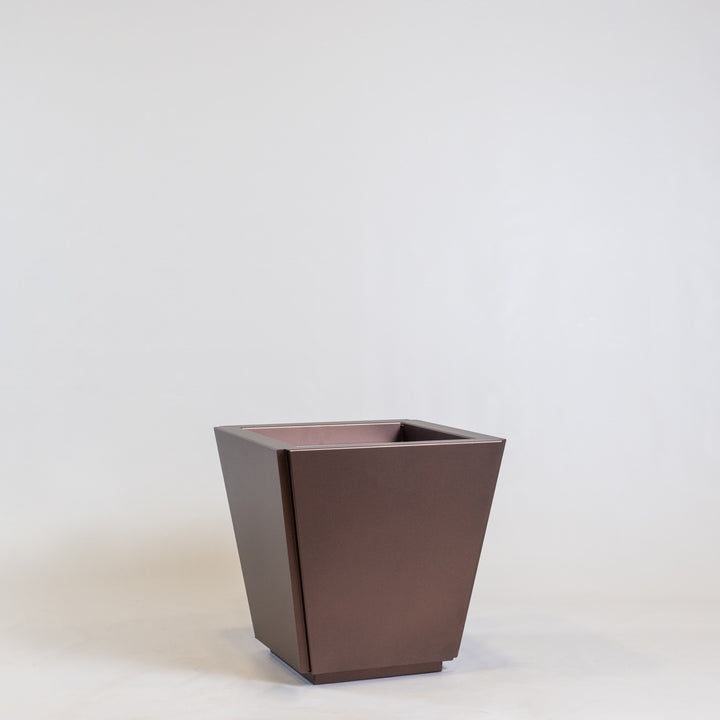 A metal cabot planter in copper on a light grey background. An all-weather steel design.