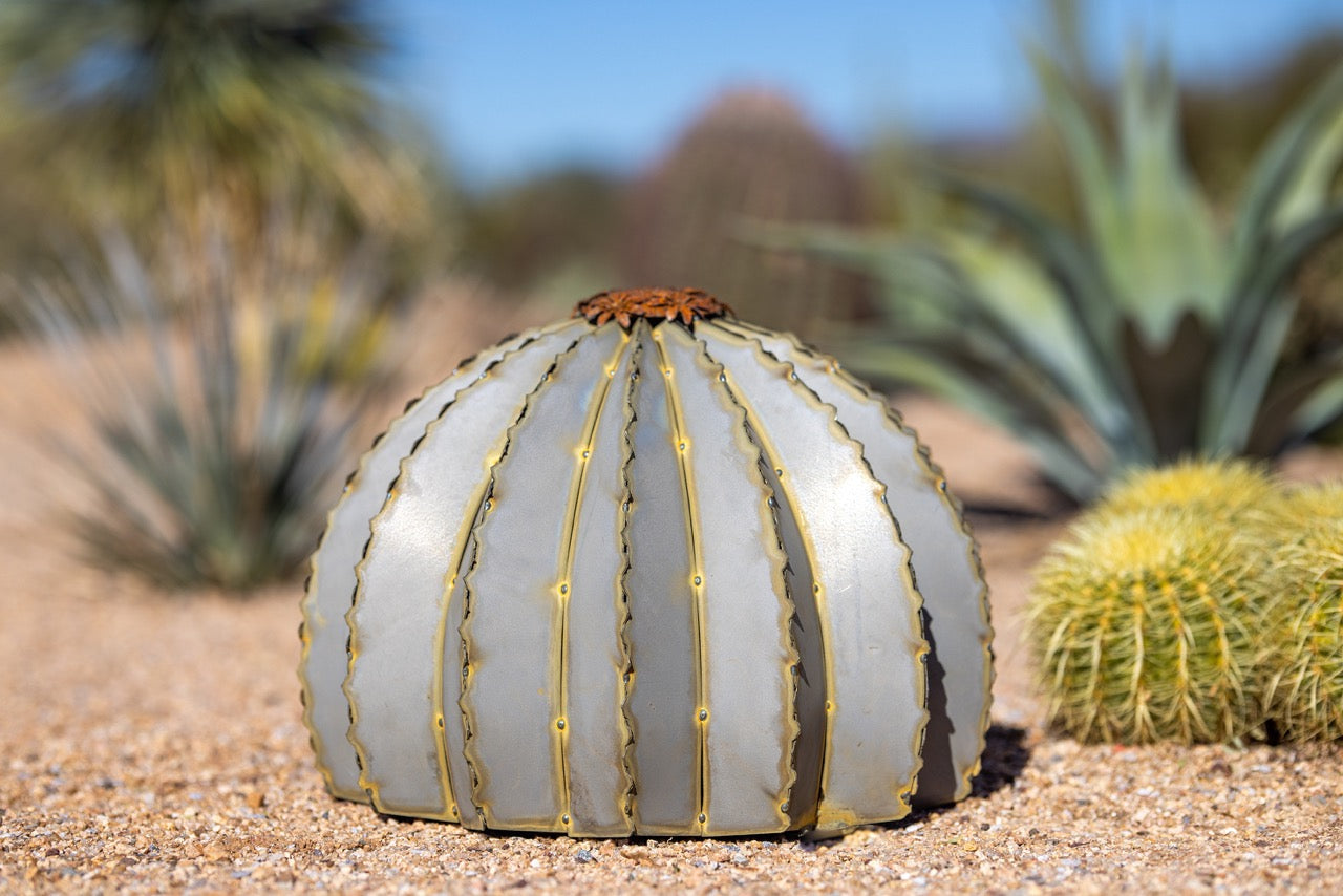 A small golden metal barrel cactus torch in a white background. Featuring a beautiful lifelike design to suit any landscape.