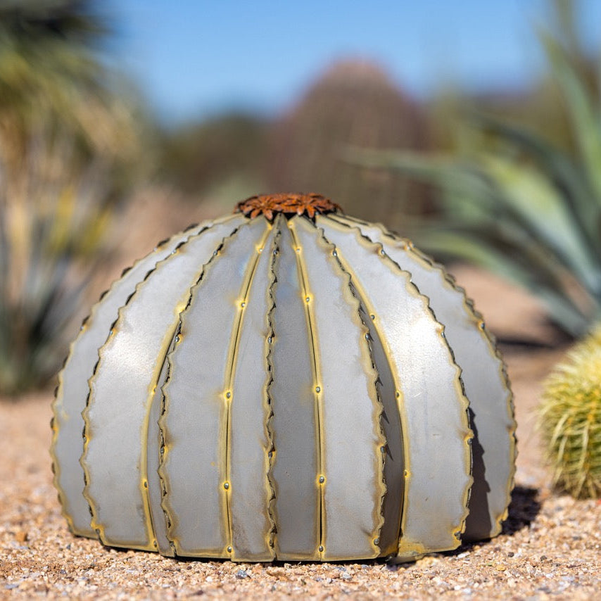 A small golden metal barrel cactus torch in a white background. Featuring a beautiful lifelike design to suit any landscape.